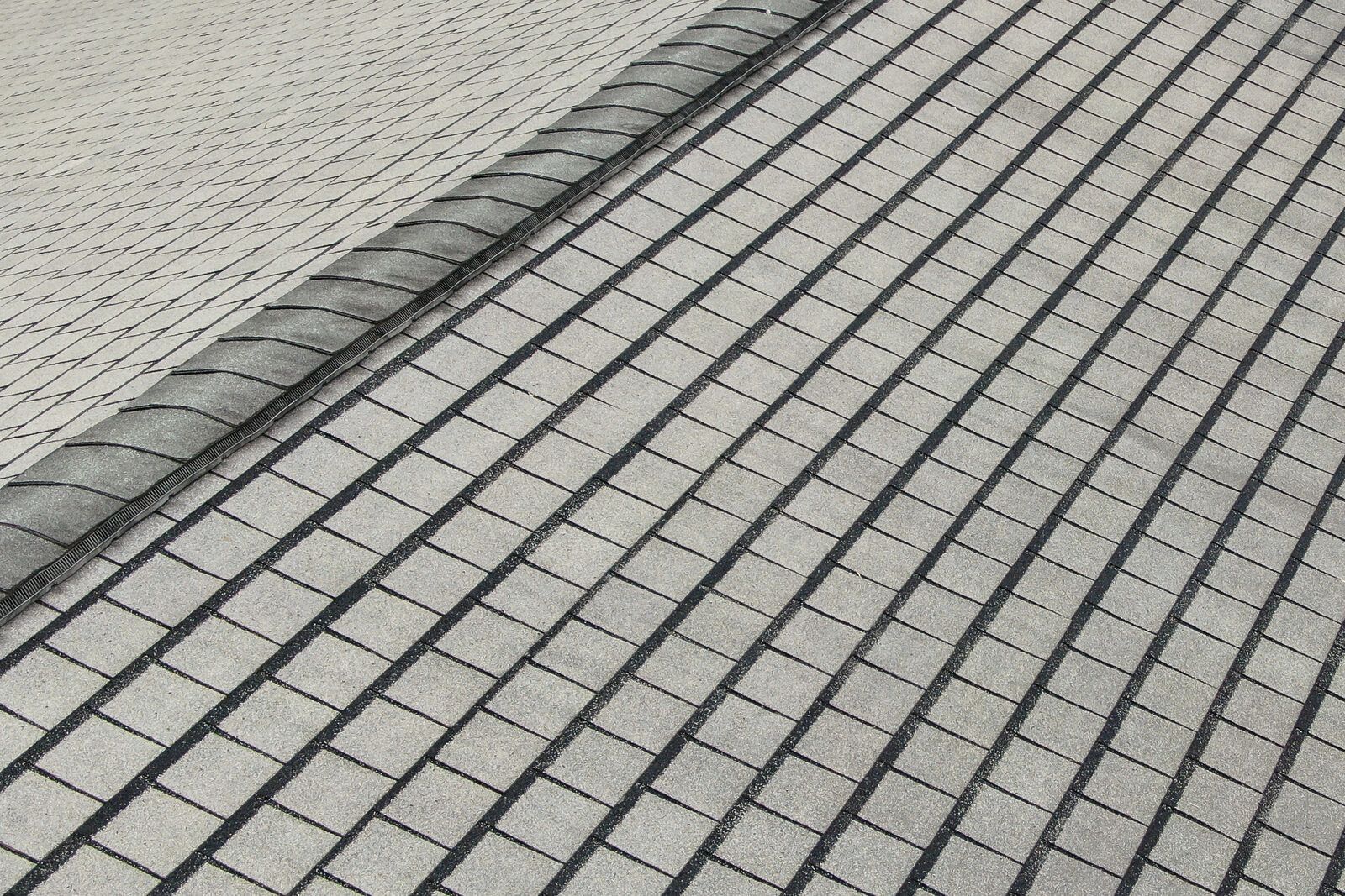 A grey shingle roof with a vented ridge, a slotted black strip running under the ridge cap shingles.